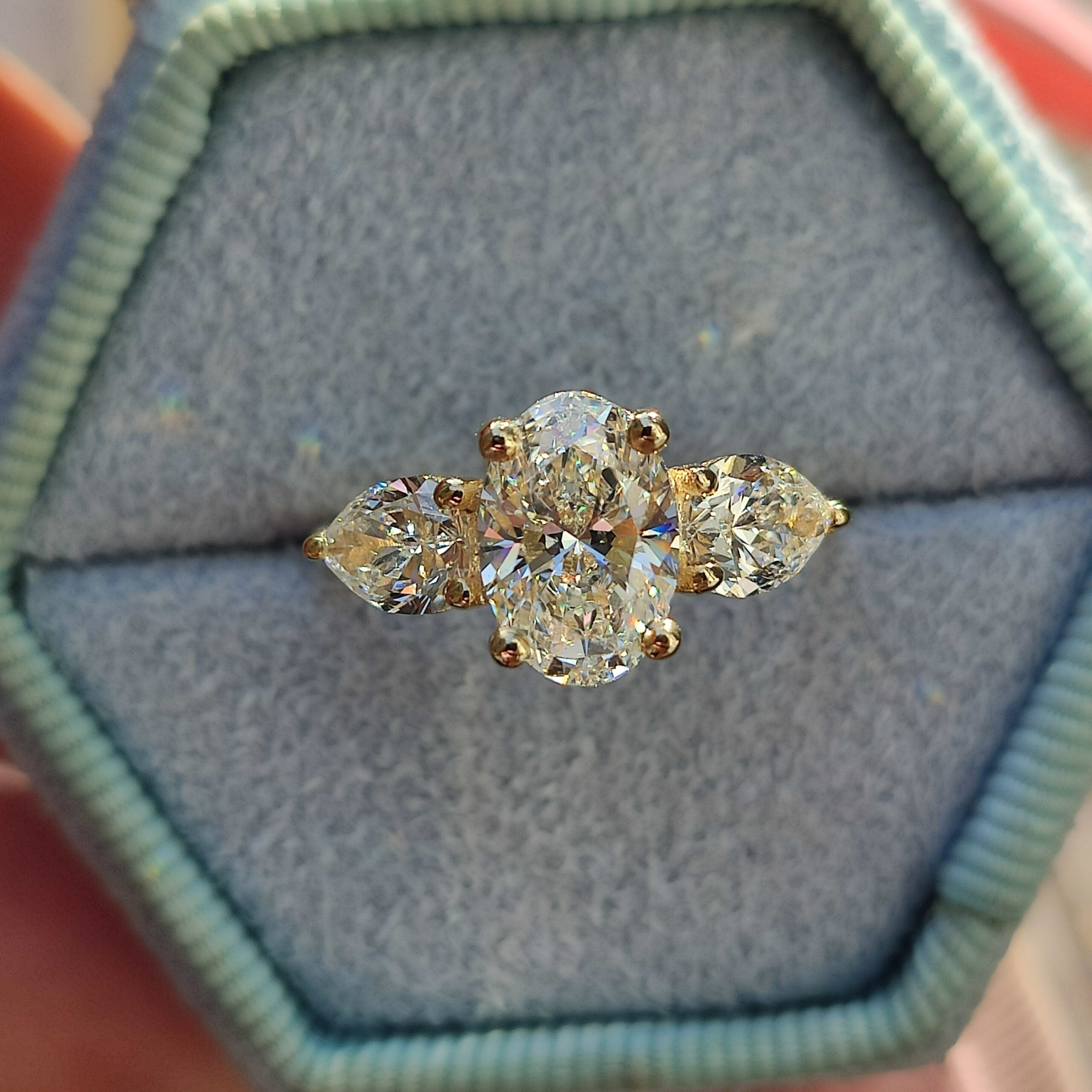 טבעת מזהב צהוב משובצת ביהלום אובלי מרכזי ושני יהלומים בצורת טיפה מסביבו