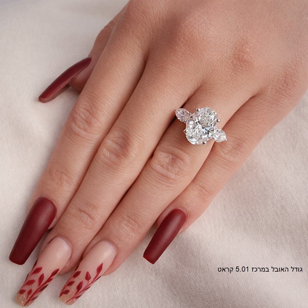 טבעת מזהב לבן משובצת ביהלום אובלי מרכזי ושני יהלומים בצורת טיפה מסביבו