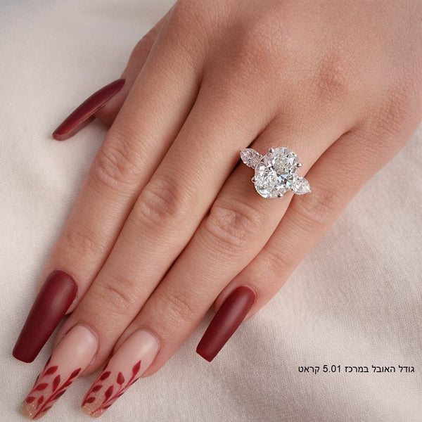 טבעת מזהב לבן משובצת ביהלום אובלי מרכזי ושני יהלומים בצורת טיפה מסביבו