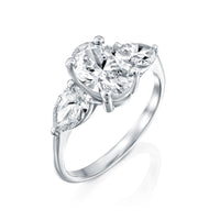 טבעת מזהב לבן משובצת ביהלום אובלי מרכזי ושני יהלומים בצורת טיפה מסביבו