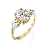 טבעת מזהב צהוב משובצת ביהלום אובלי מרכזי ושני יהלומים בצורת טיפה מסביבו