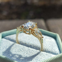 טבעת מזהב צהוב משובצת ביהלום אובלי מרכזי ושני יהלומים בצורת טיפה מסביבו