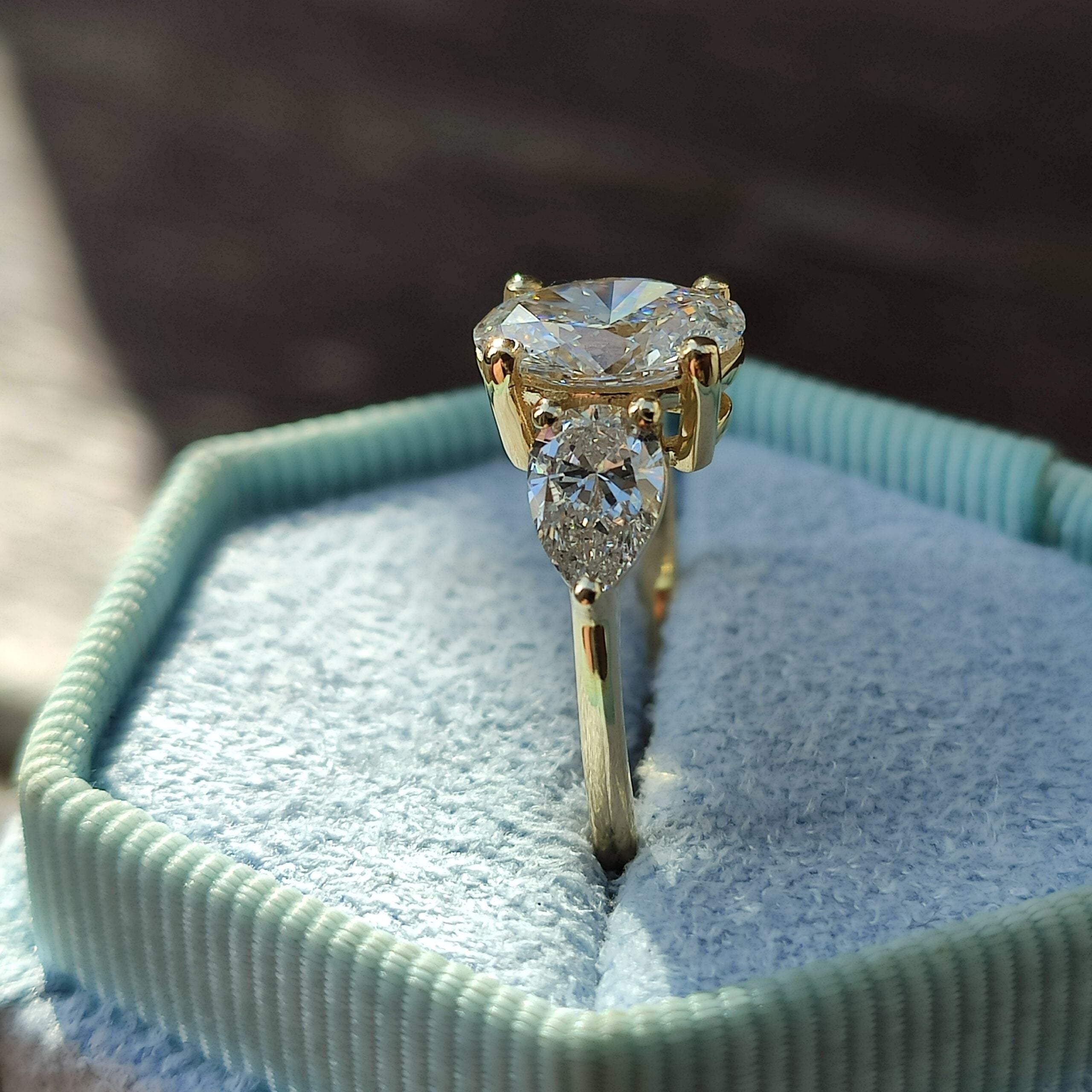 טבעת מזהב צהוב משובצת ביהלום אובלי מרכזי ושני יהלומים בצורת טיפה מסביבו