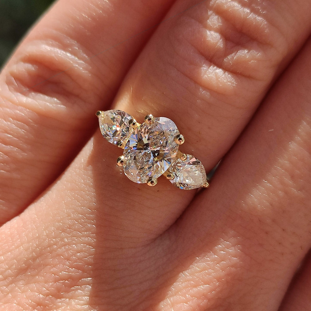 טבעת מזהב לבן משובצת ביהלום אובלי מרכזי ושני יהלומים בצורת טיפה מסביבו